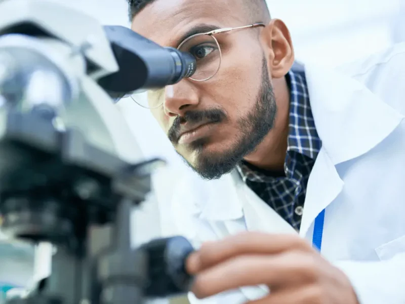 Scientist looking through microscope